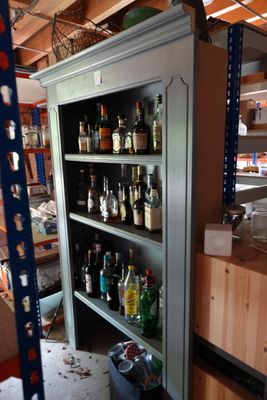 a tall cabinet that has a lot of bottles on it