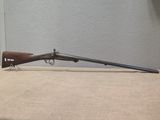 un fusil au canon en bois posé sur une table devant un mur