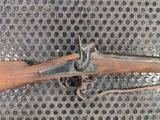 a rifle with a wooden handle on a metal surface