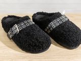 the black slippers are on a wooden surface with a chain around them