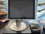 a computer monitor sitting on a desk with a cell phone next to it
