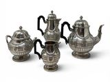 three pieces of silver tea and coffee set on a white surface