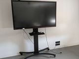 a flat screen tv sitting on a stand in the corner of a room