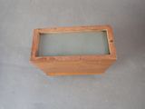 a small wooden box with a glass top on the floor