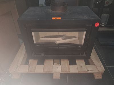 a black stove sitting on a pallet in a room