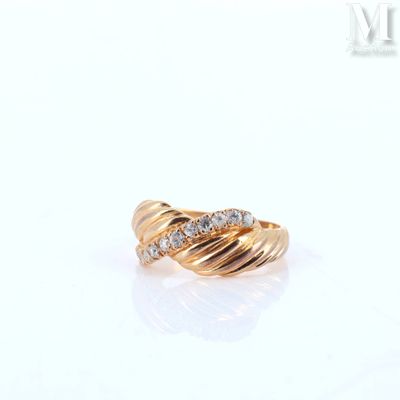 a close up of a gold ring with diamonds on a white surface