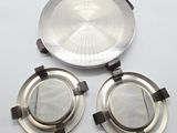 two silver metal plates with lids and handles on a white surface