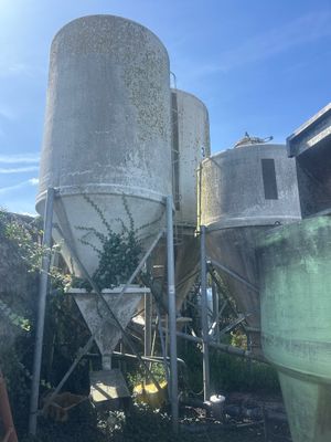 a man standing in front of two cement silos