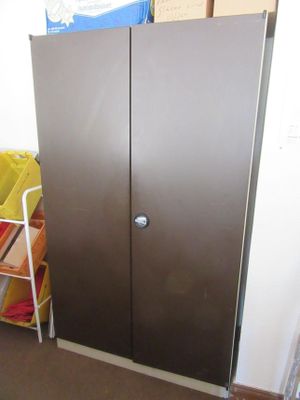 a metal door in the corner of a room next to a shelf
