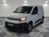 la camionnette blanche est garée sur un sol en damier dans le garage