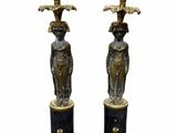 pair of black and gold candlesticks with figures on them