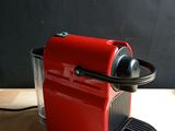 a red coffee machine sitting on a wooden table