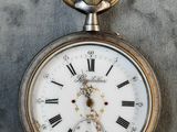 un gros plan d'une montre de poche avec des chiffres romains