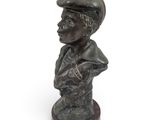 bronze bust of a boy with a hat on a wooden base