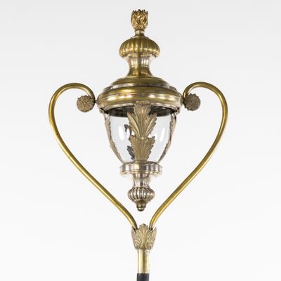 une lampe en laiton à l'ancienne, surmontée d'un abat-jour en verre