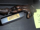 une statue en bronze représentant une main tenant une bouteille de vin