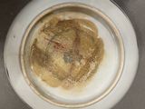 a white bowl with a brown substance in it