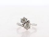 a close up of a diamond ring on a white surface