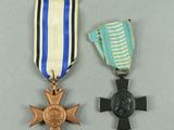 two medals are placed next to each other on a gray surface