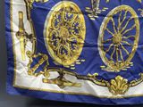 une écharpe bleue et dorée sur laquelle est représentée une horloge