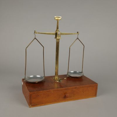 une image représentant une balance sur laquelle sont posées deux assiettes argentées