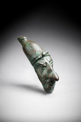 un gros plan d'un objet en bronze sur lequel figure un visage
