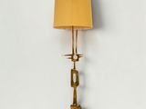 a brass floor lamp with a yellow shade on top of it