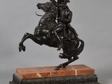 an antique bronze statue of a man on a horse on a marble base