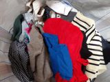 a pile of clothes sitting on top of a bed