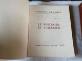 a book that is open on a table next to other books