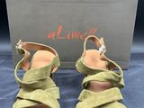 une paire de sandales en daim vert pour femme, avec une boîte