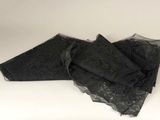 three pieces of black lace on top of a white surface