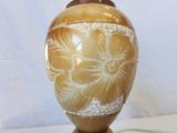 a brown vase with a flower design on it