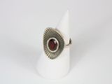 a close up of a ring with a red stone in it