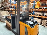 forklift in a warehouse with pallets and boxes in the background