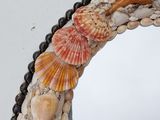 a mirror made out of shells and seashells on the wall