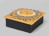 yellow and black box with a sun design on top of it