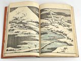 an open book with a picture of a mountain in the background