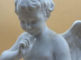 statue of an angel with a flower in his hand