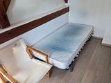 une photo d'une chambre avec un lit et une chaise