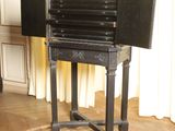 an old black table that has a closed door on it