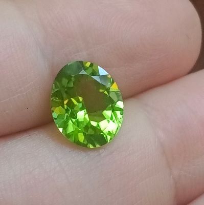 quelqu'un tient une pierre précieuse verte dans la main
