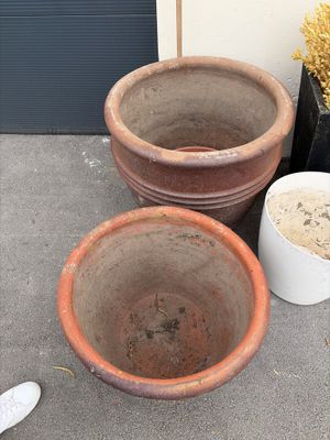 deux grands pots en terre cuite posés l'un à côté de l'autre par terre