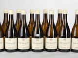 six bouteilles de vin sont alignées sur une table