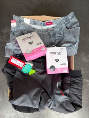le contenu d'un carton de vêtements est étalé sur le sol