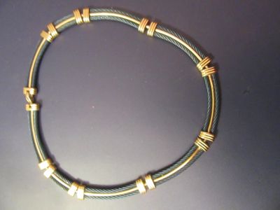 une photo d'un collier en fil métallique et en or