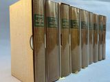 six books are lined up in a row on a white surface