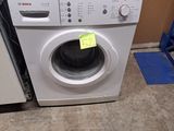 une machine à laver et un sèche-linge placés l'un à côté de l'autre dans une pièce