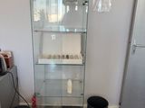 une vitrine en verre dans le coin d'une pièce