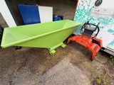 a green boat sitting on the ground next to a white truck
